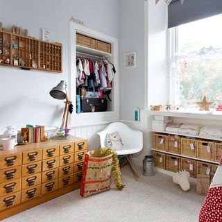 childrens room with white wall and vintage cabinets
