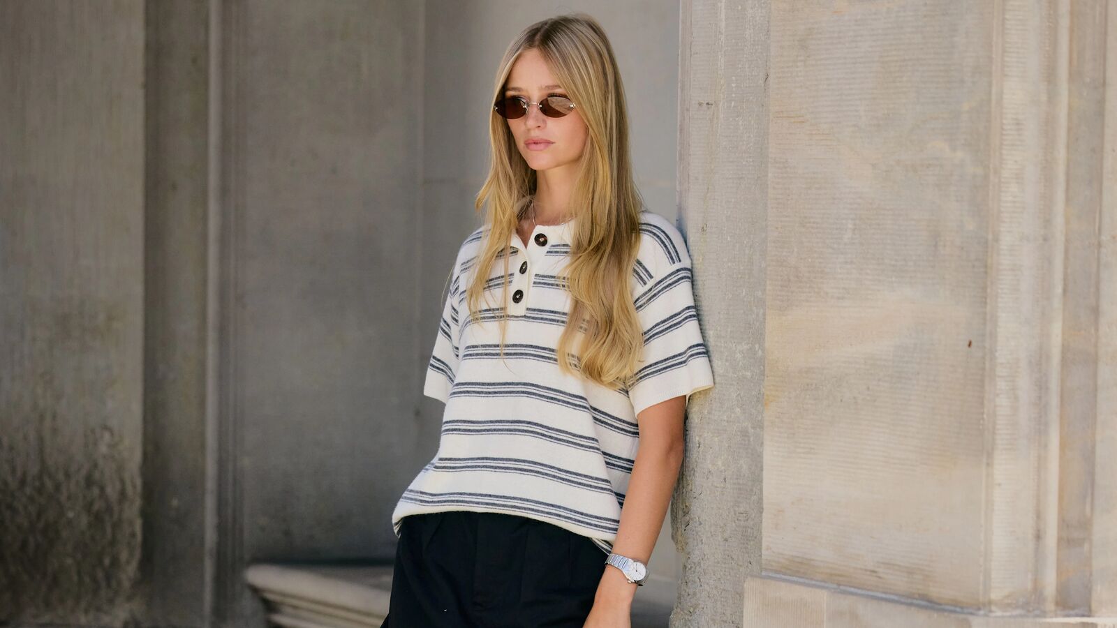 Woman at Copenhagen Fashion Week wearing a striped polo shirt and a black skirt