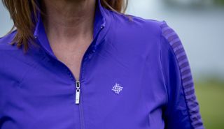 A female golfer wears the Famara Sheer Sleeve Golf Shirt