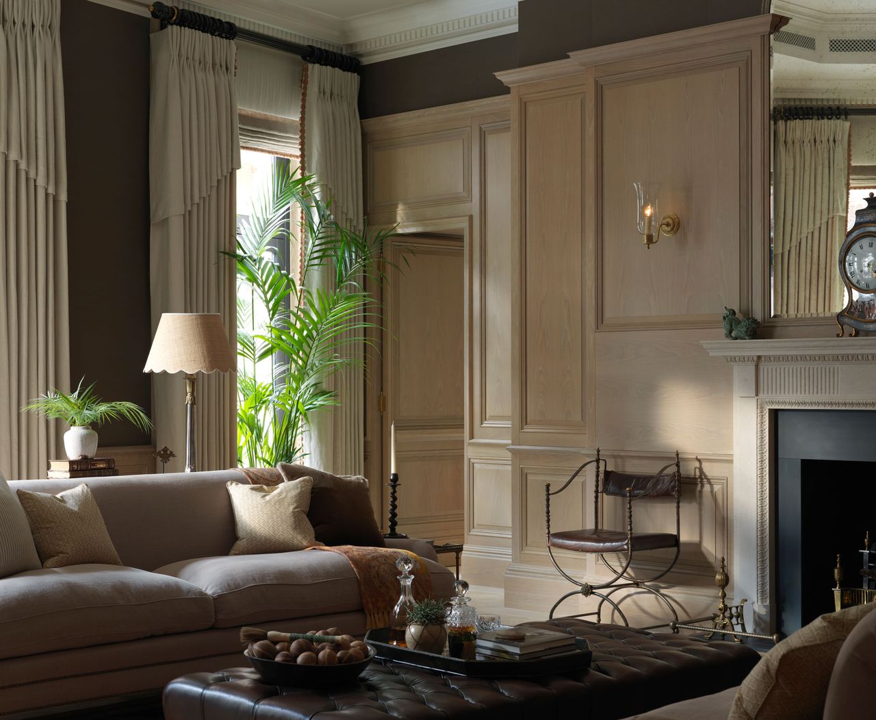 classic living room with panelling and trad features, neutral scheme with wall light and table lamp, full drapes 