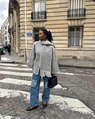 Influencer and athlete Marilyn wearing a grey scarf coat and jeans