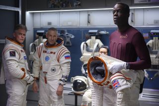 (left to right) Jack Willmore (Martin Cummins), Misha (Mark Ivanir) and Kwesi (Ato Essandoh) suit up aboard a lunar base in