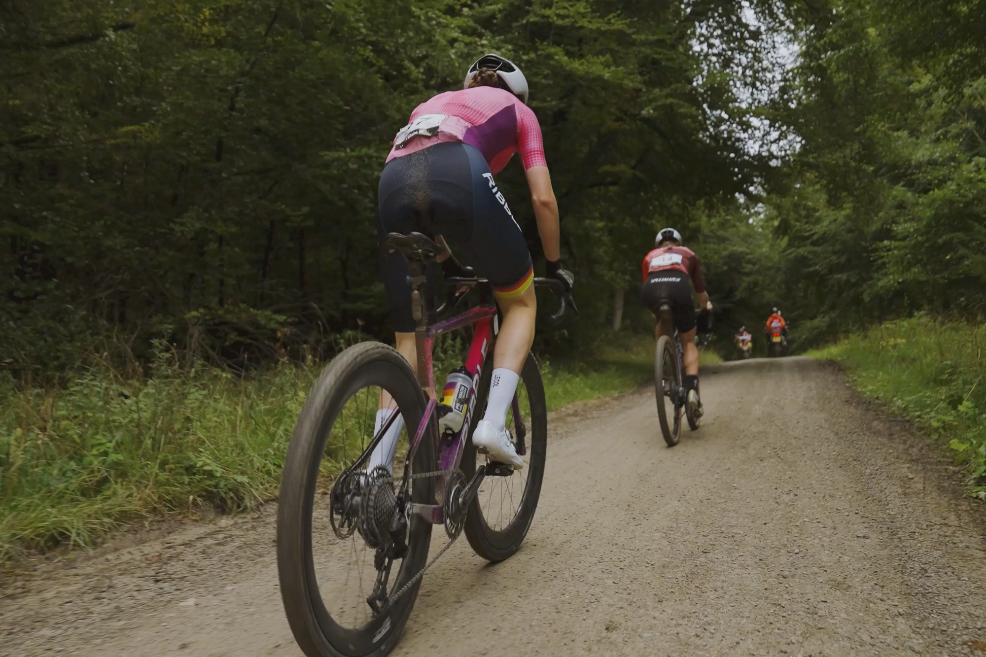 A pink and purple Ribble gravel bike being used by both male and female athletes on a misty day at British Gravel Champs