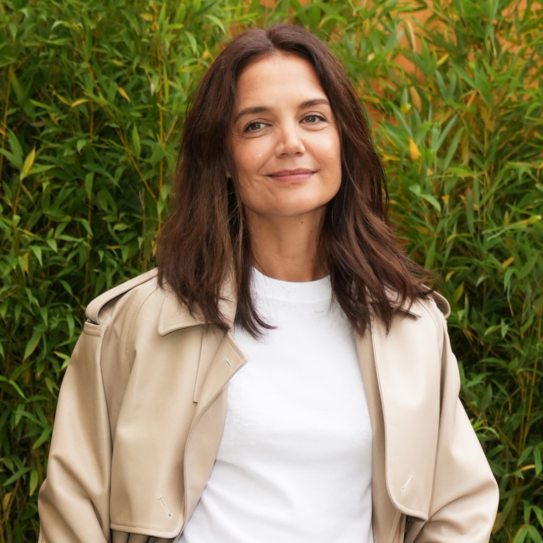 Katie Holmes at Milan Fashion Week wearing a trench coat and classic loafers