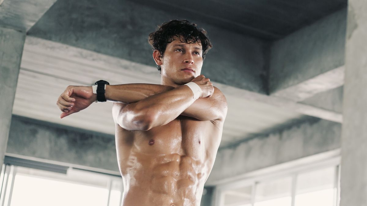 a photo of a strong man in the gym stretching his arms