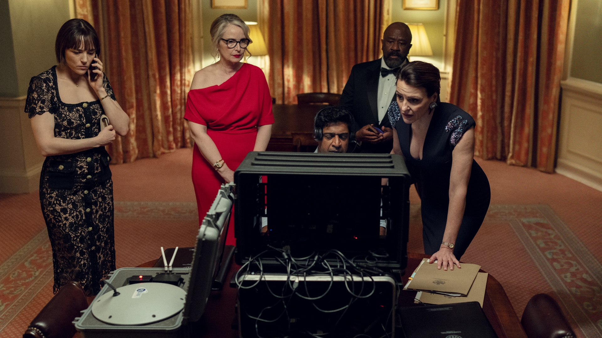 The team gather round a computer in Hostage