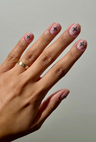 A manicure featuring starburst art and rhinestones by Iram Shelton.