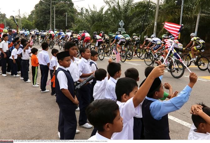 Schoolchildren cheer on the peloton