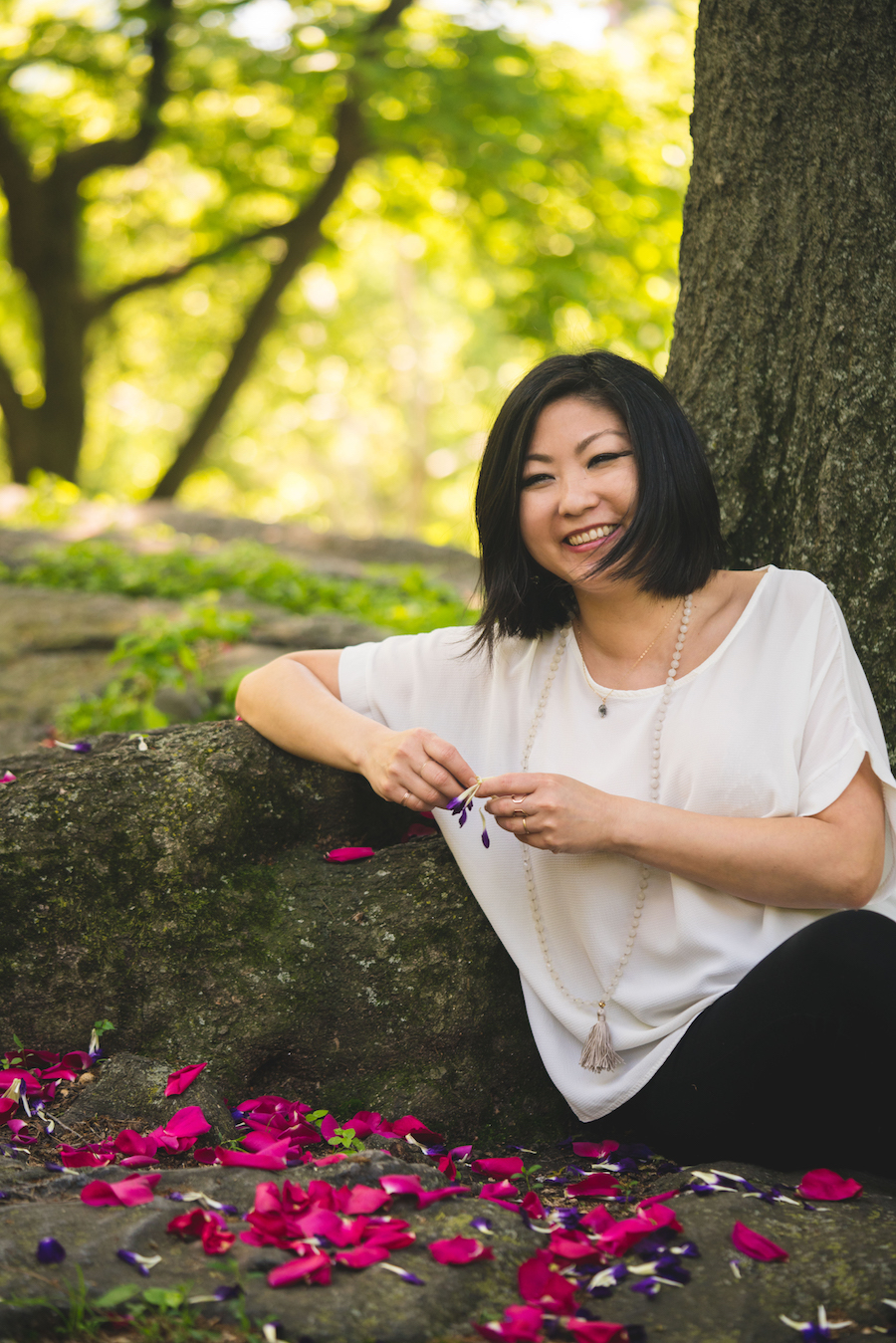 Anjie Cho sitting by a tree