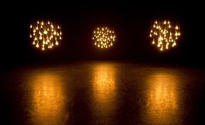 Three groups of pendant lights hanging over a stage.