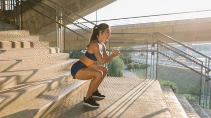 A woman performing a squat as part of a leg workout