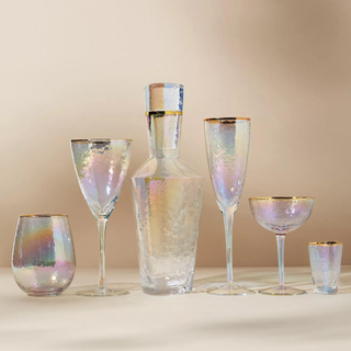 A collection of coup glassware and a glass cocktail shaker