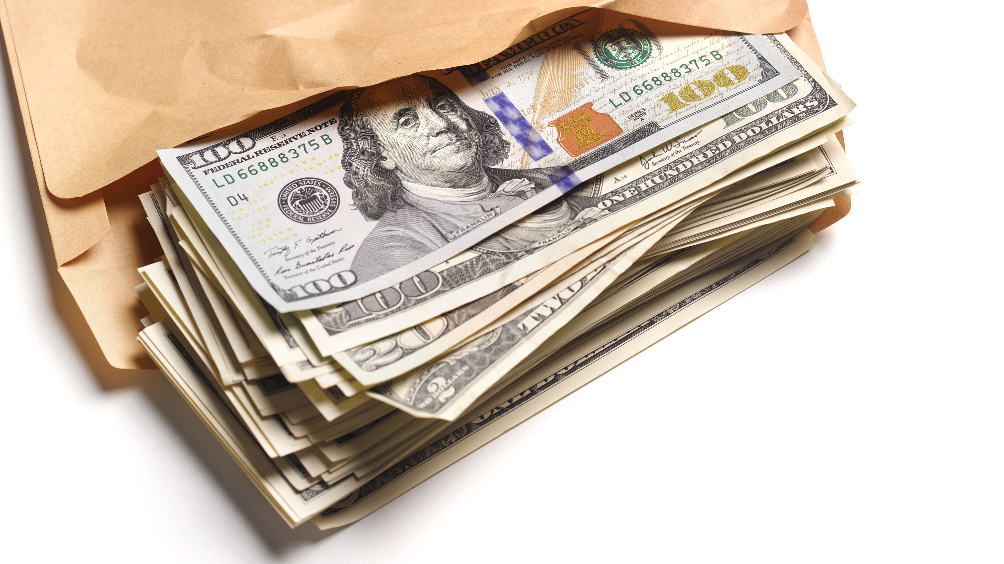 Cash spills out of a manila envelope.