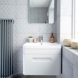 bathroom with grey tiles white vanity unit and mirror