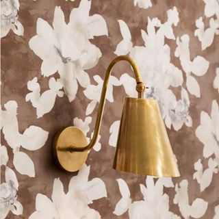 Pink floral wallpaper with a gold sconce
