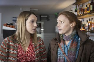 Cassie (Erin Armstrong) and Meg (Lucianne McEvoy) exchange a concerned look inside the wine bar where Cassie works
