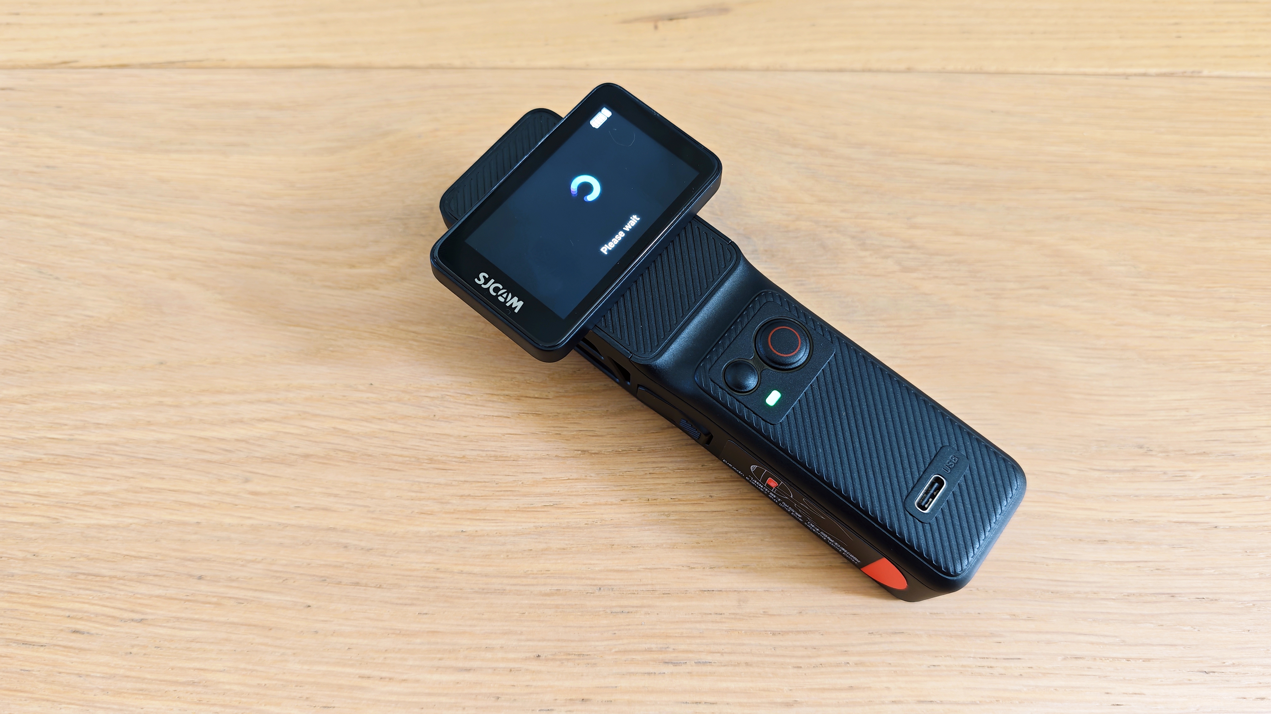 An SJCAM C400 on a wooden surface