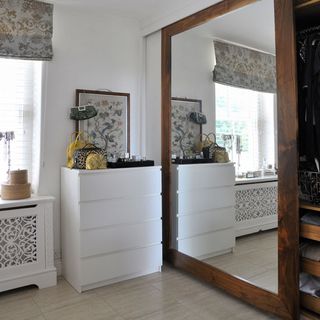 room with white drawer and mirror