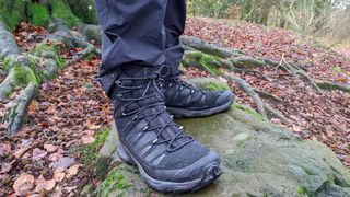 Man standing on rock wearing Salomon Mens Ultra Trek GTX High Rise boots