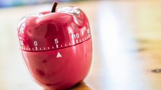 A kitchen timer shaped like an apple set on five minutes.