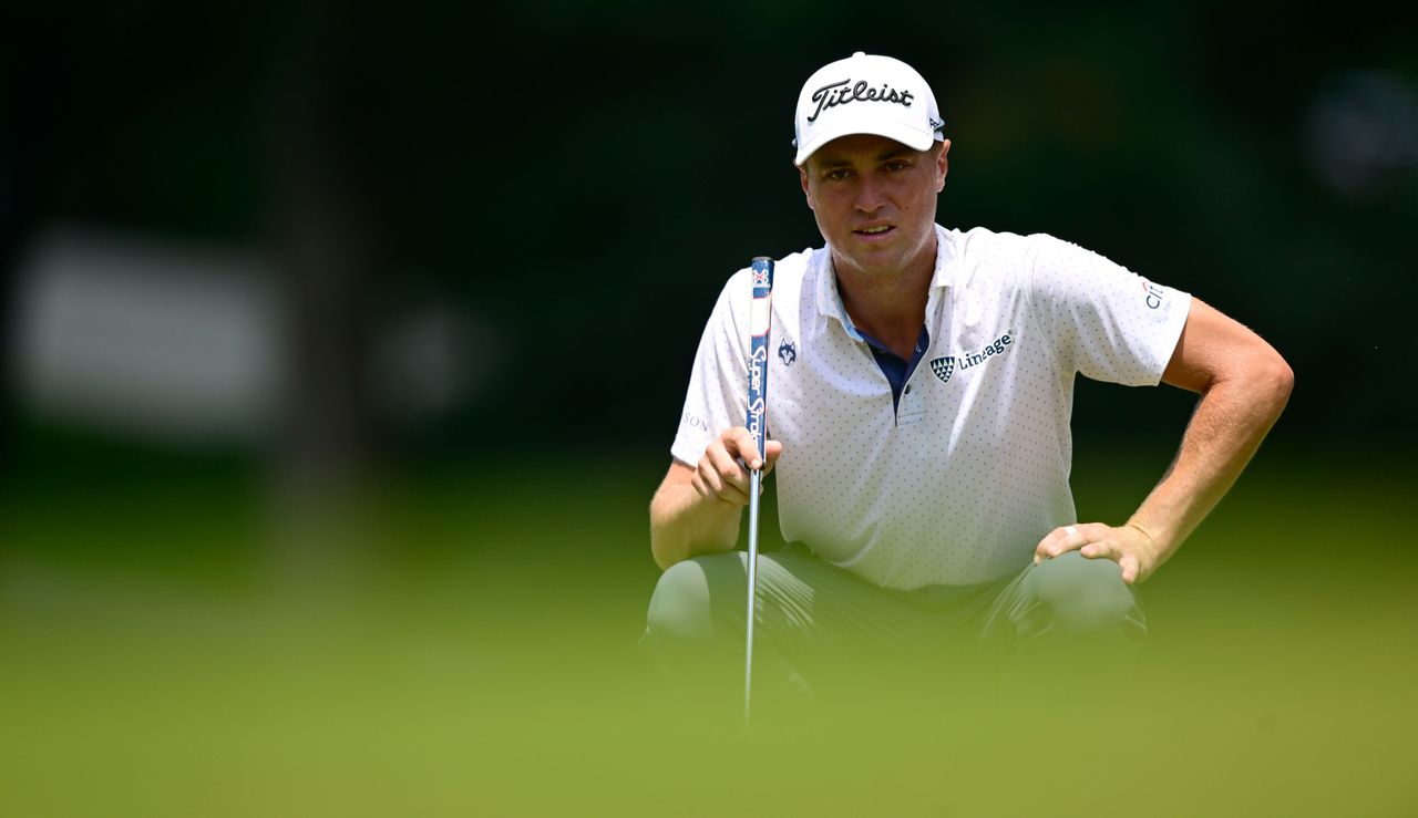 Justin Thomas lines up his putt on the green