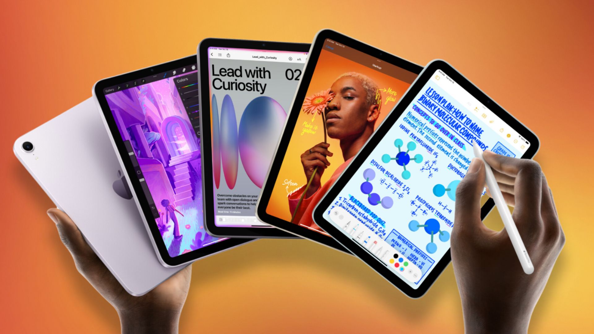 Hands holding five iPads and Apple Pencil in front of an orange background