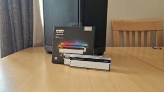 Klevv Cras XR5 RGB DDR5 RAM standing against a its box and Corsair PC case