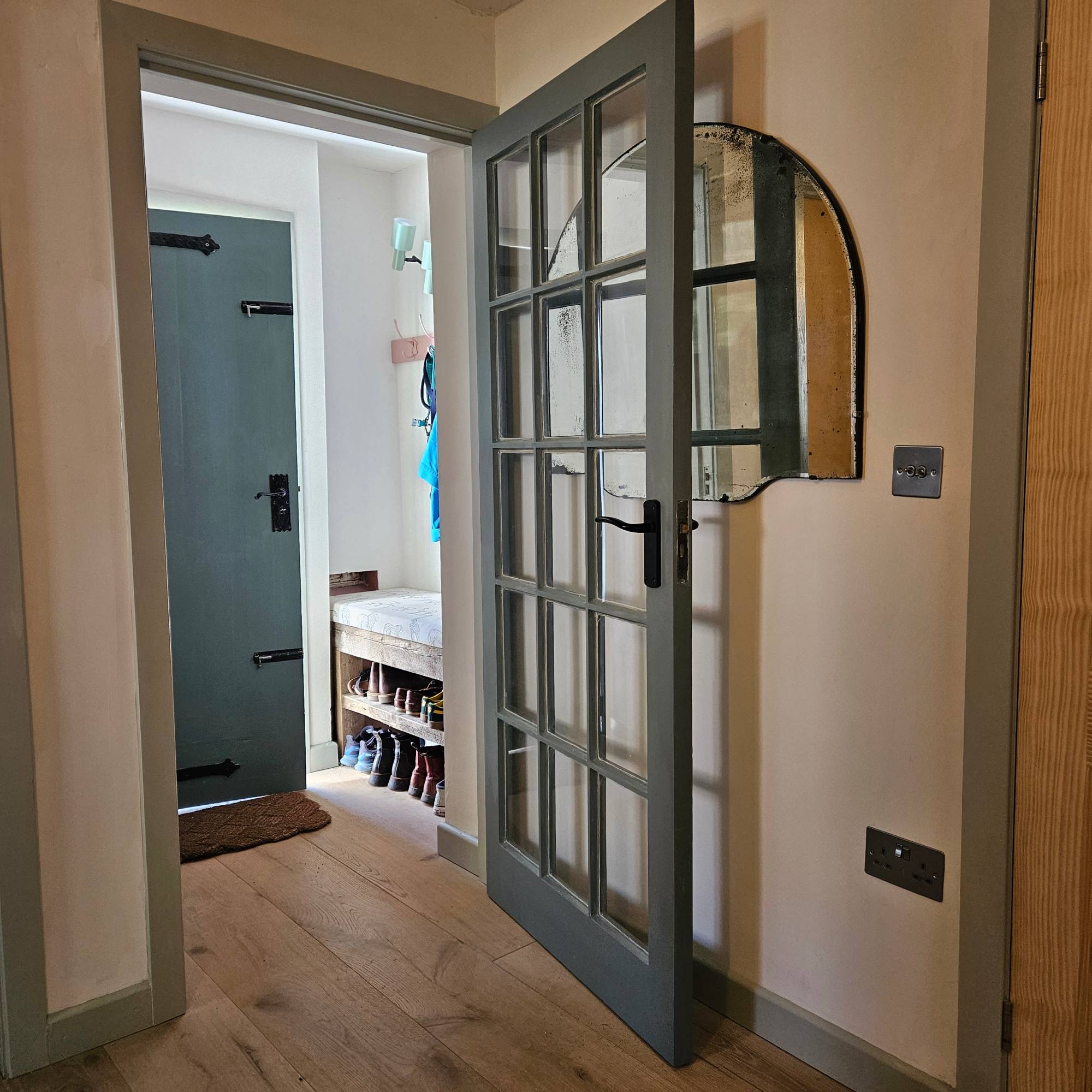 white porch with green door and mirror