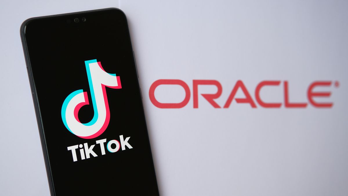 Phone displaying TikTok logo with Oracle logo in the background