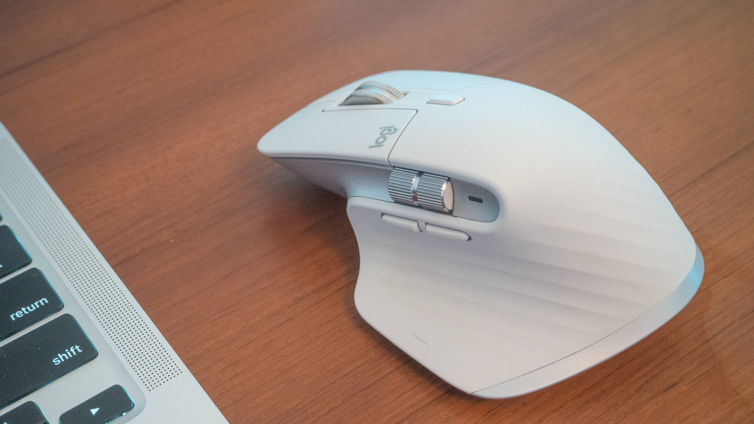 A white Logitech MX Master 3S for Mac mouse on a brown wooden desk