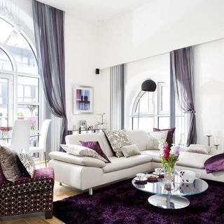 living room with white sofa magenta rug and white walls