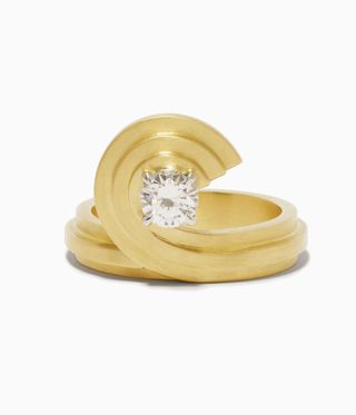 Gold ring curving round a single diamond