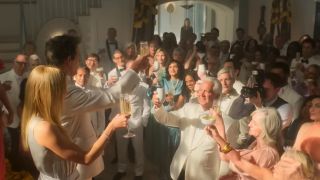 Kevin Bacon holding up a glass and making a toast in Sirens