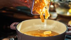 Glass jar of pasta being poured into casserole dish