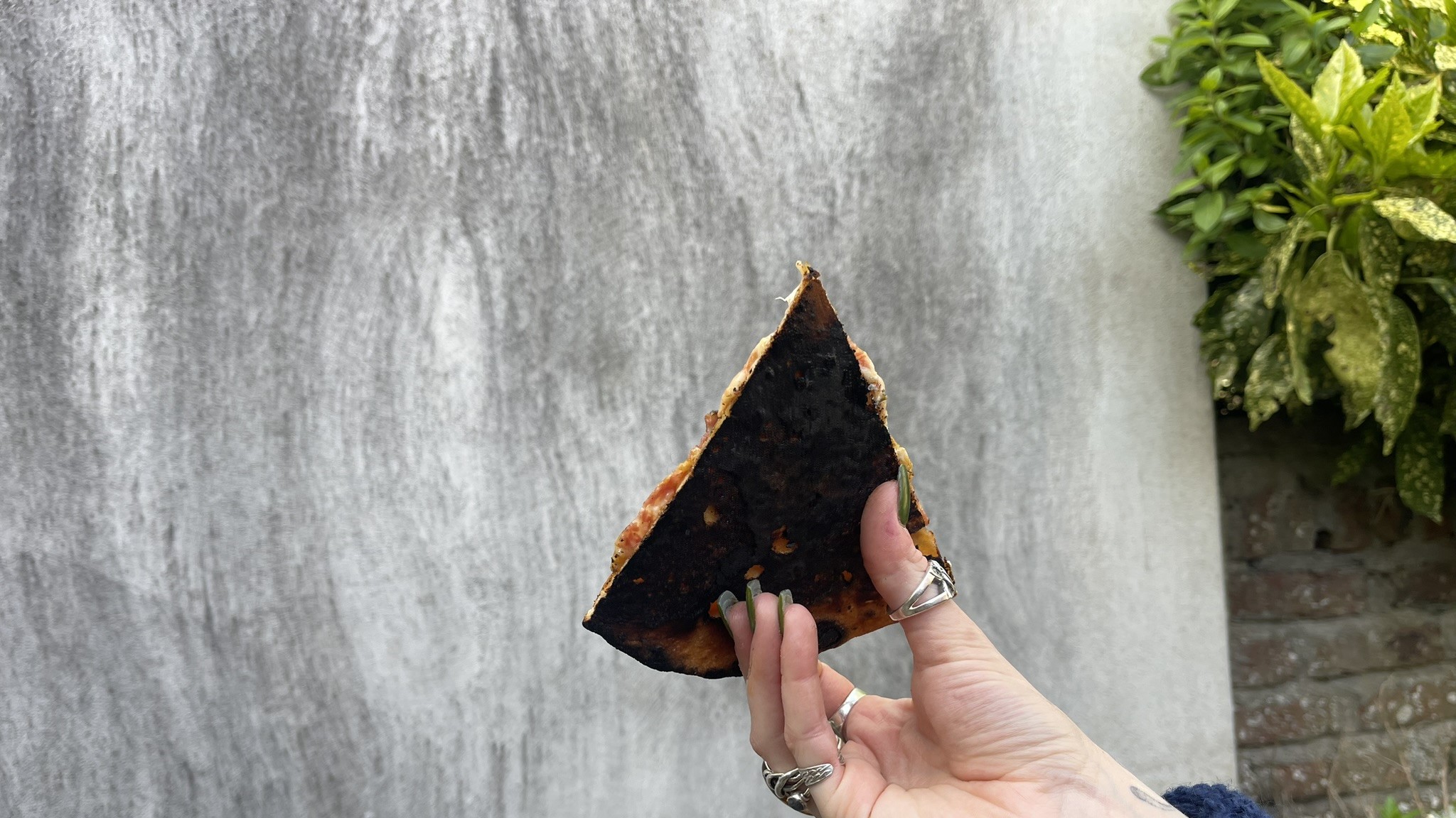 The black bottom surface of a pizza cooked by the Ooni Volt 12