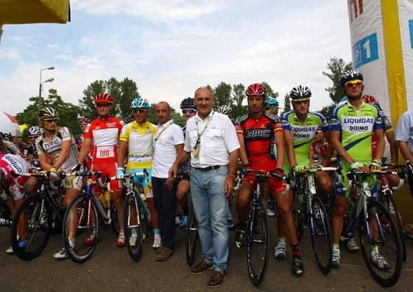 Riders await the start of stage three, dedicated to Franco Ballerini. Paolo Bettini, the new Italian national team manager, stands next to race leader Allan Davis (Astana).