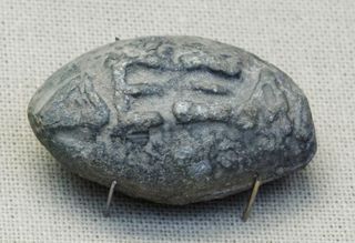 This sling bullet from the fourth century B.C., found at Athens, shows the Greek word ΔΕΞΑΙ ("dexai") in high relief.