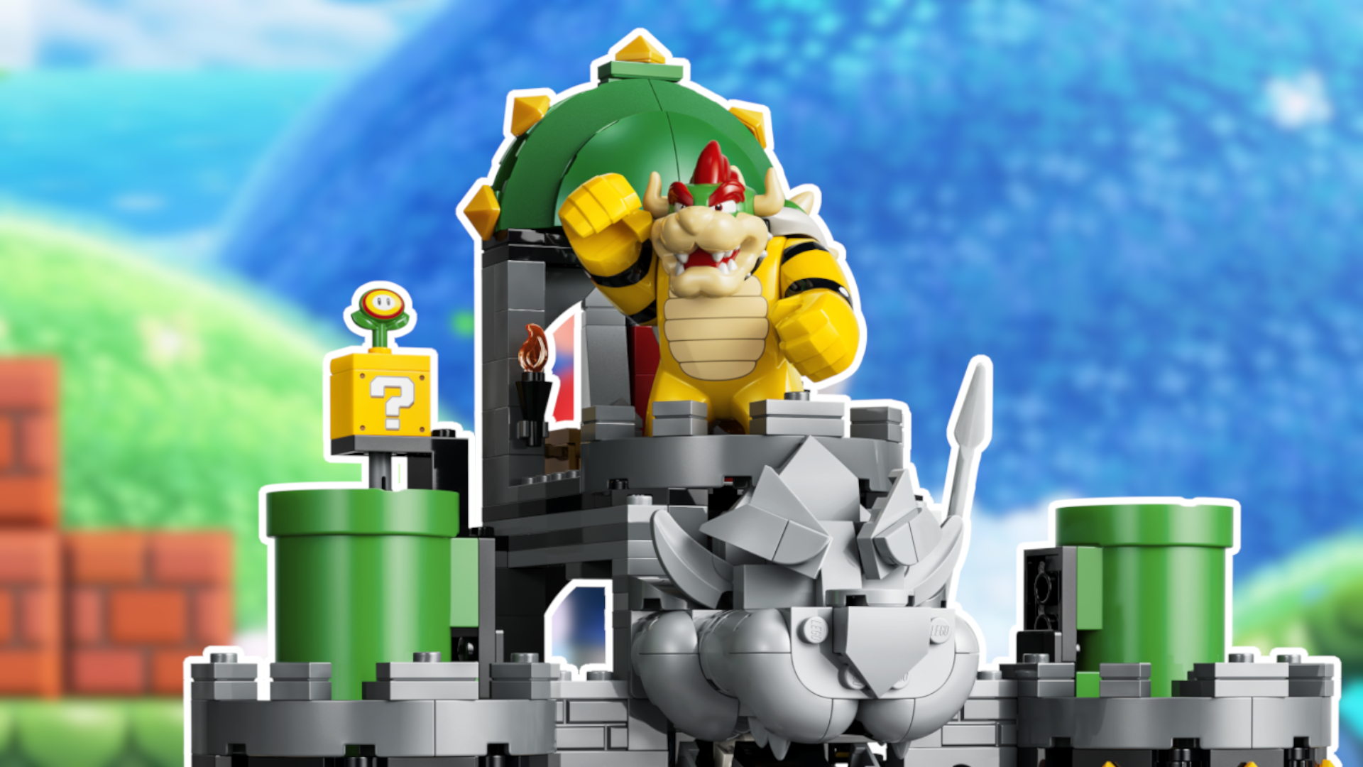 Lego Bowser figure atop his castle, with rolling hills from the Mushroom Kingdom visible in the background