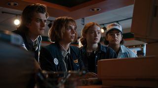 Steve, Dustin, Max, and Robin looking surprised at a computer screen in Stranger Things 4