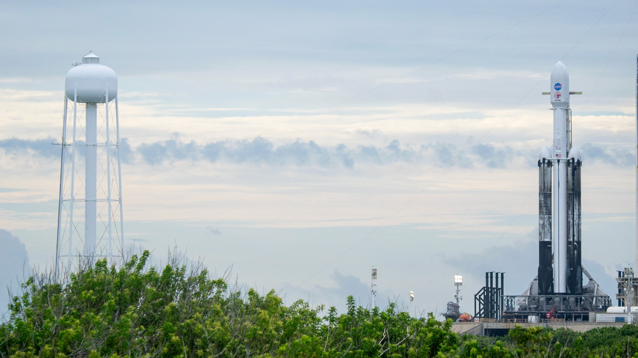 a falcon heavy rocket with sooty side boosters stands at lc-39a for NASA's Psyche mission, Oct. 11, 2023.