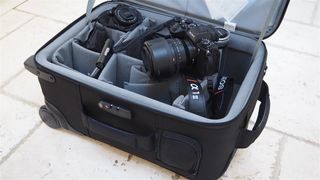 Tenba Roadie Air Case Roller 21 camera bag filled with camera gear on a stone flag floor