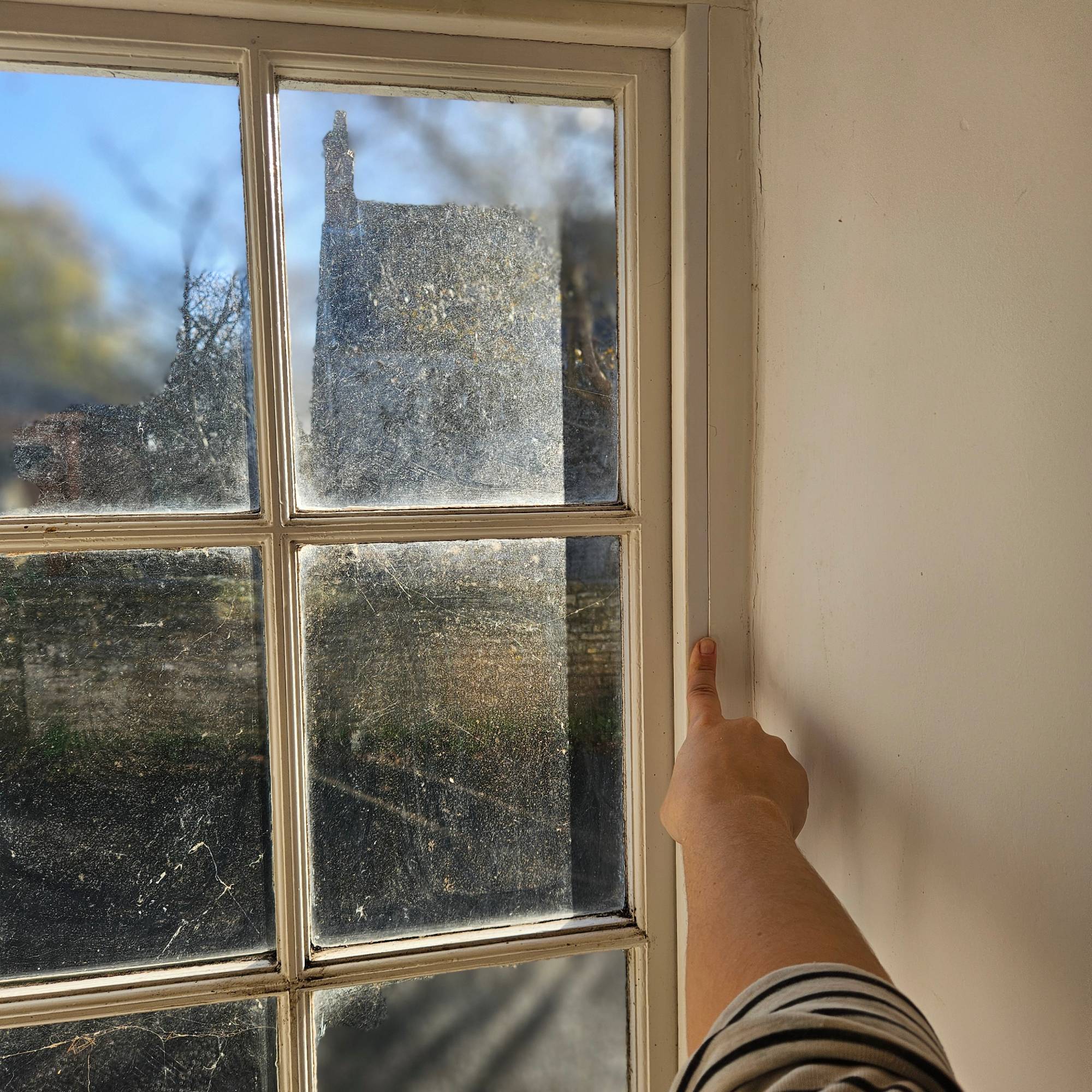 installing secondary glazing film on white sash window