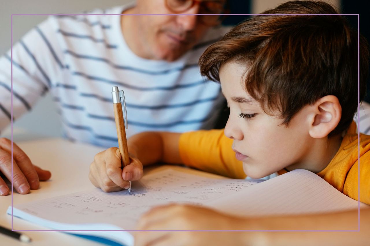 man in striped tee overseeing sullen boy doing homework