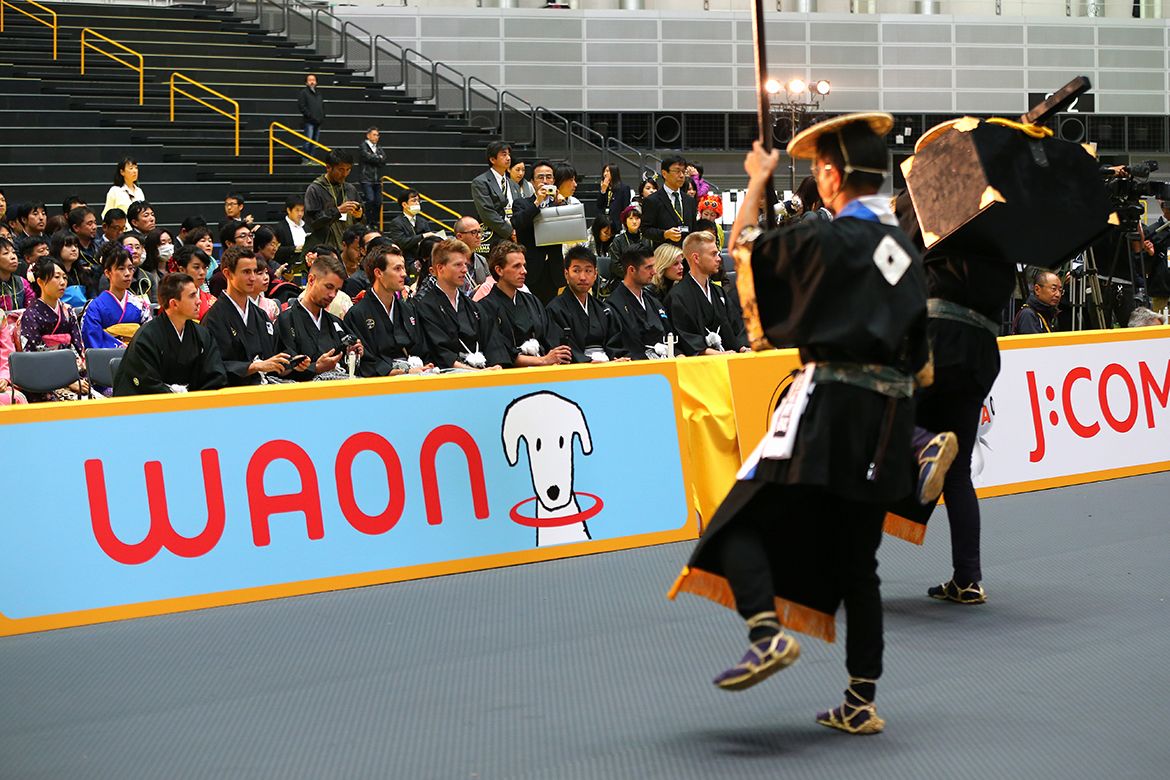 The riders watch a performance in the Saitama Super Arena