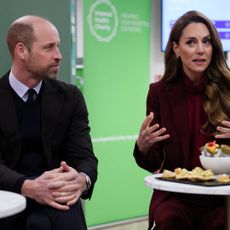 Prince William sitting next to Princess Kate at a table