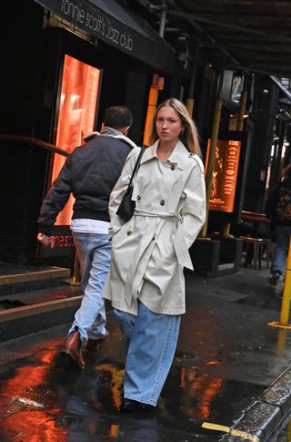 Lila Moss wears a trench coat and jeans.