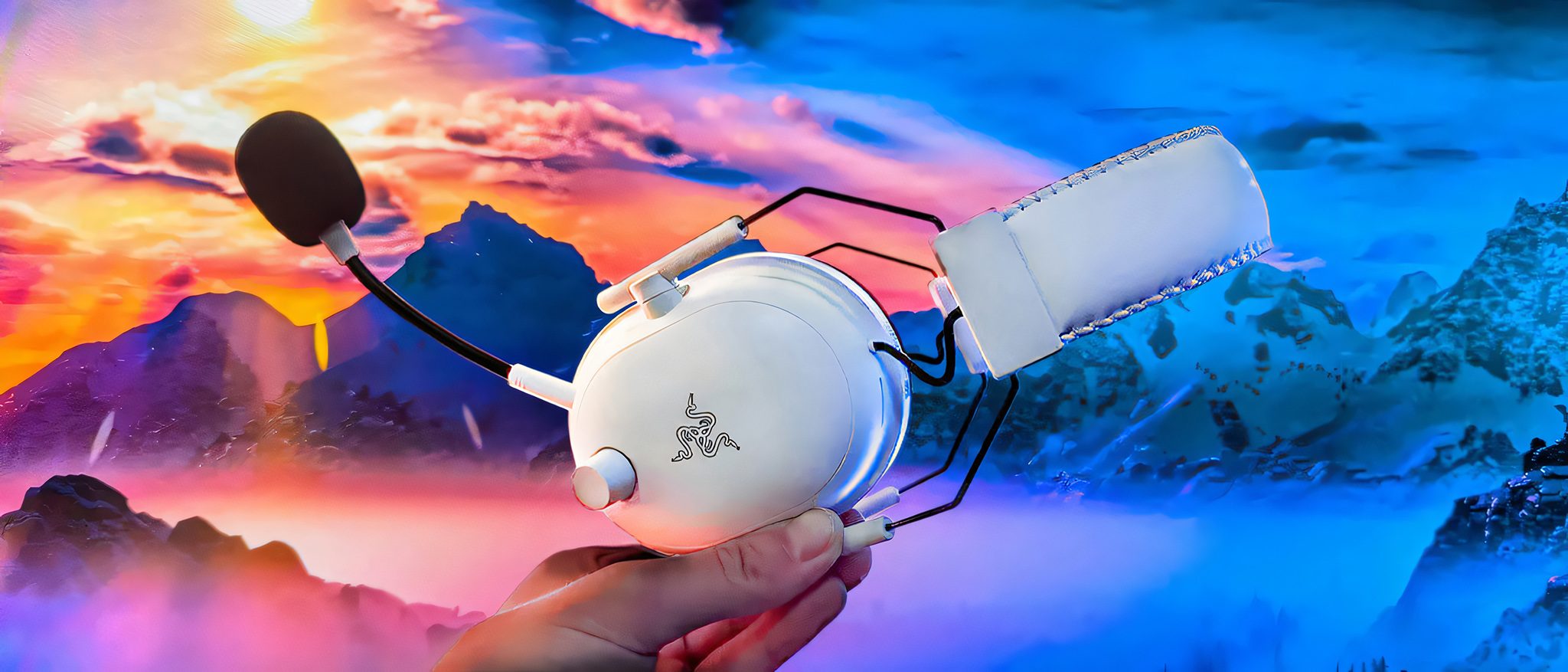 The Razer BlackShark V2 Pro being held by a hand in front of a colorful landscape. 