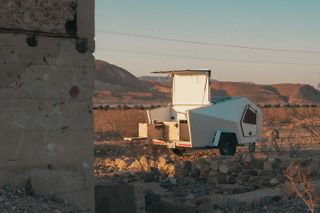 Travel trailer with open roof in desert landscape