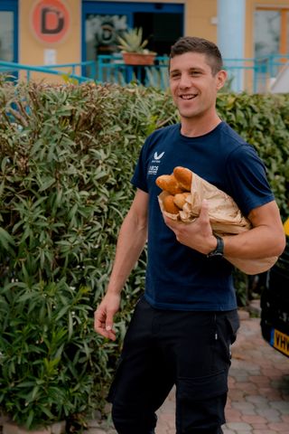 A team soigneur fetching bread for riders ahead of Giro d'Italia stage