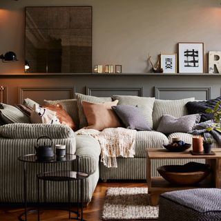 living room with grey wall shelf and grey designed sofa with designed cushion
